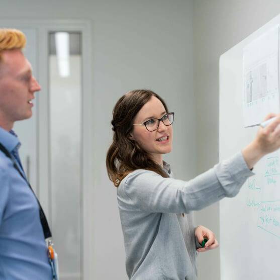 Woman pointing at whiteboard